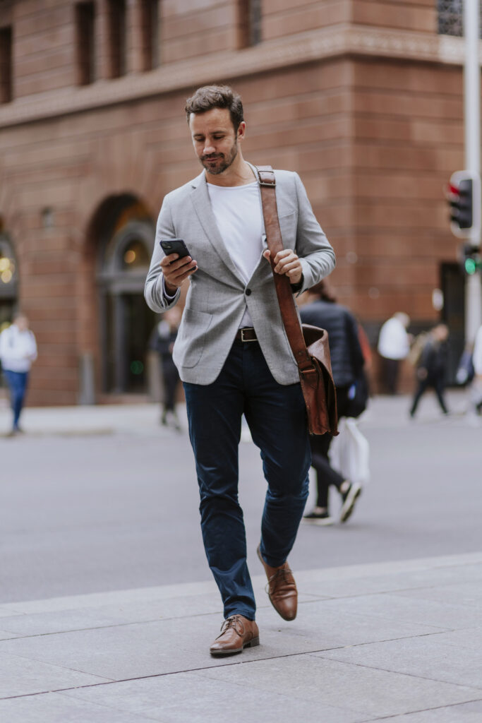 Trendy man checks his messages on his way to his office