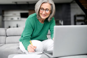 Confident mature woman using laptop computer while planning retirement